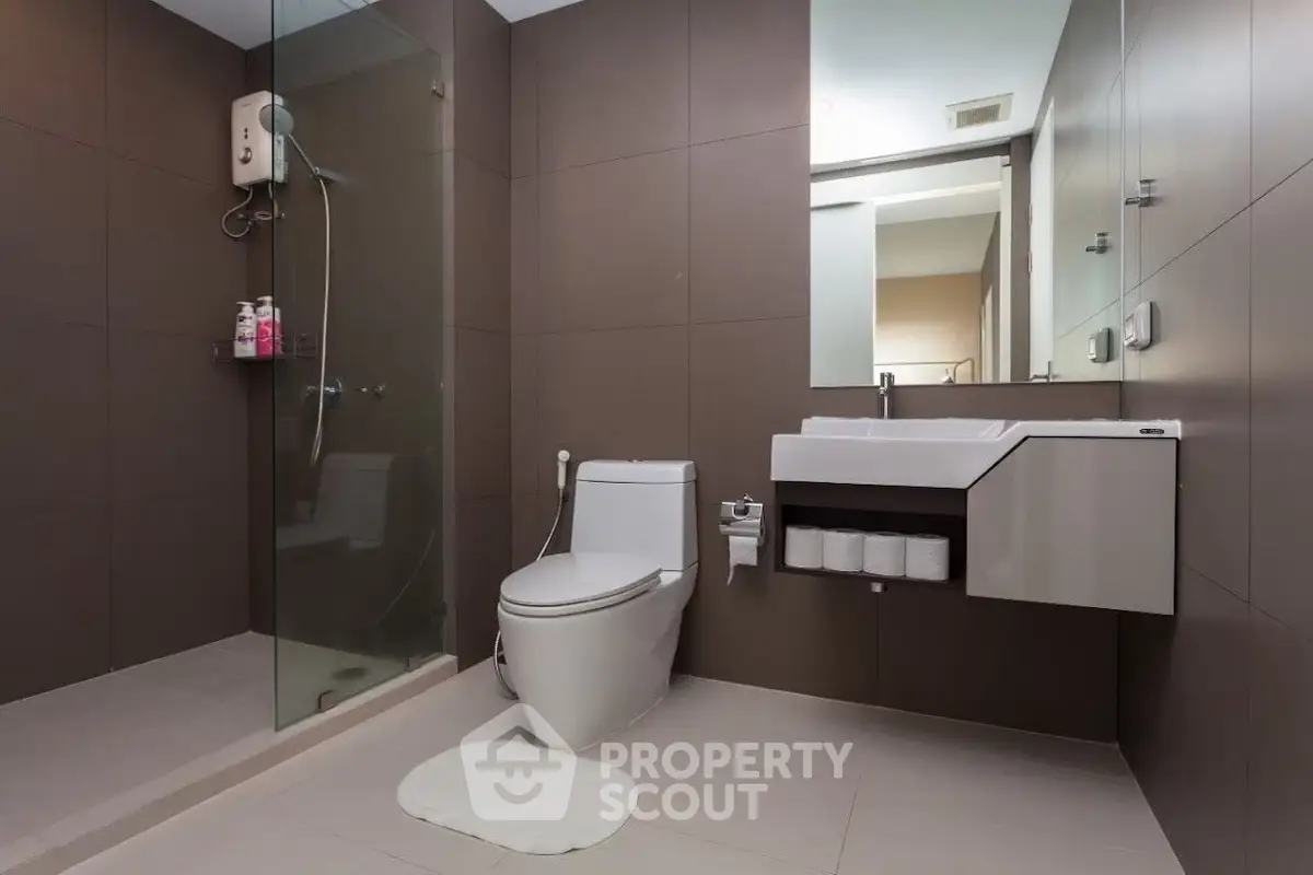 Modern bathroom with glass shower and sleek fixtures in a contemporary home.