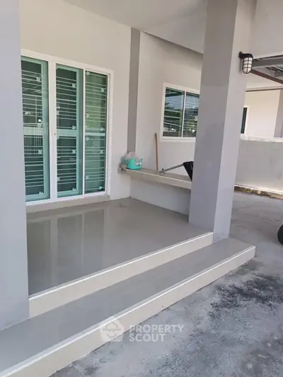 Modern home entrance with sleek glass doors and clean architectural lines.