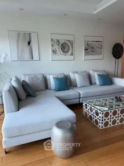 Modern living room with stylish gray sectional sofa and artistic decor