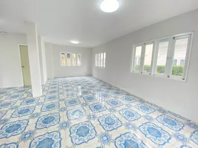 Spacious room with patterned tile flooring and large windows for natural light.