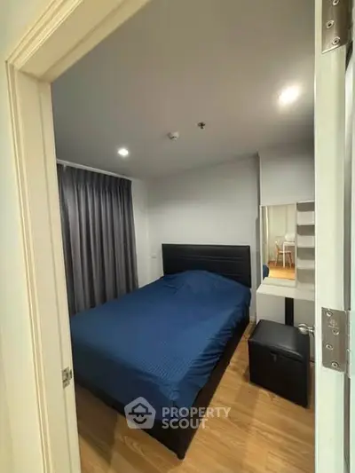 Cozy bedroom with modern furnishings and wooden flooring, perfect for a restful retreat.