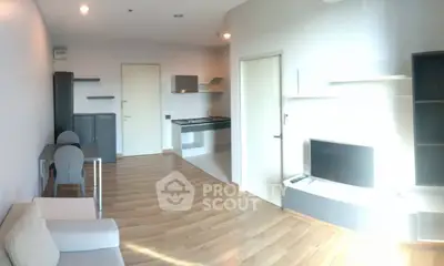 Modern living room with open kitchen and sleek furniture in a bright apartment.