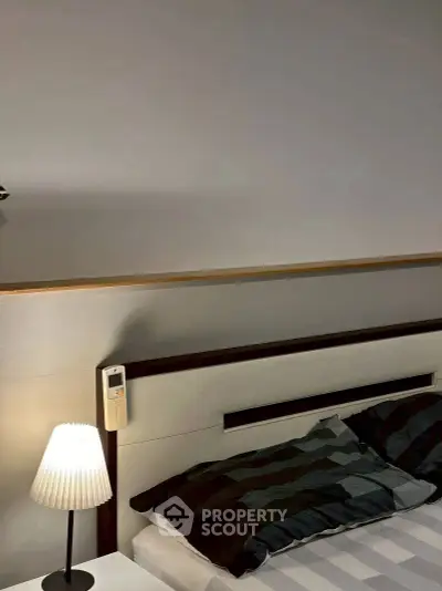 Modern bedroom with stylish lamp and cozy bedding