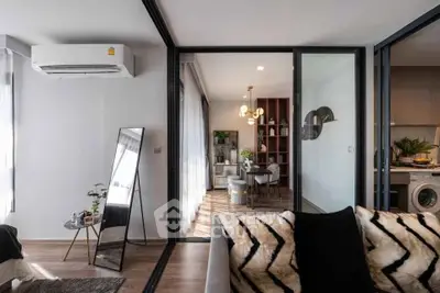 Modern living room with stylish decor and open layout, featuring a cozy dining area and sleek appliances.