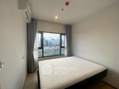 Modern bedroom with large window and city view, featuring a comfortable bed and air conditioning.