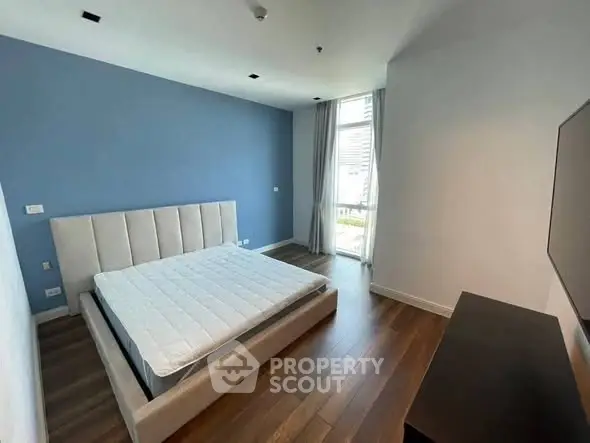 Spacious modern bedroom with large window and stylish decor