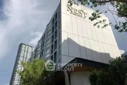 Modern condominium building with sleek design and large windows in urban setting.