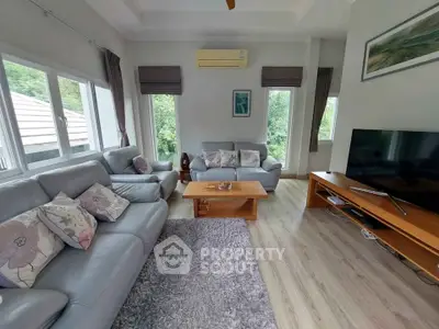 Spacious living room with modern decor and large windows offering natural light.