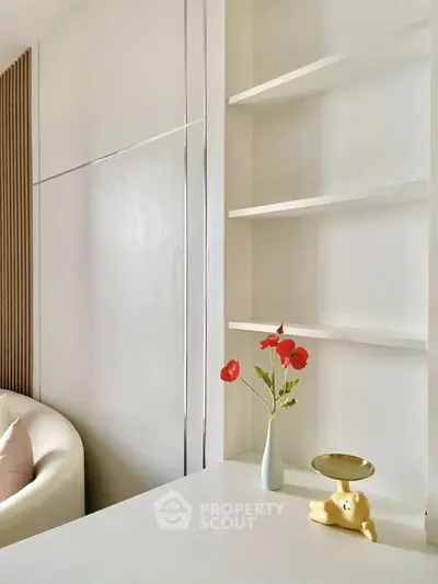 Minimalist living room with white shelves and modern decor, perfect for stylish urban living.