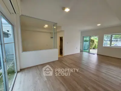 Spacious modern living room with large windows and wooden flooring