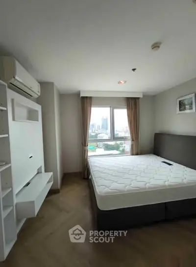 Modern bedroom with city view, featuring a comfortable bed and air conditioning.