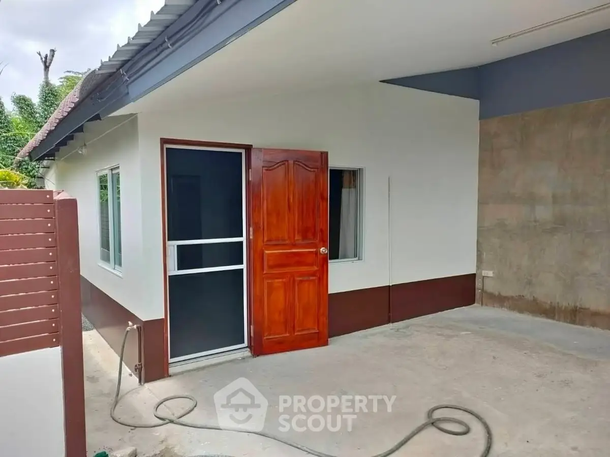 Charming single-story home with wooden door and spacious driveway.