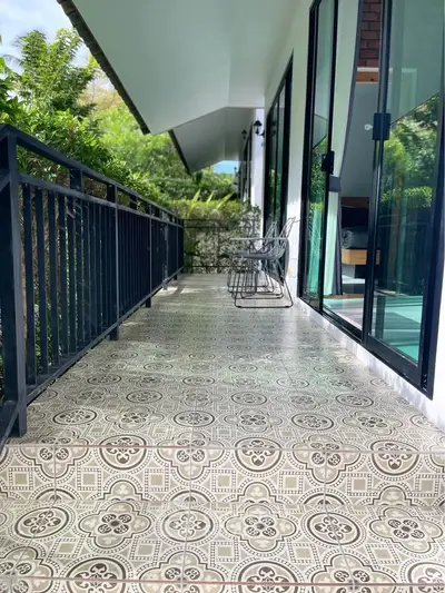 Charming balcony with decorative tiles and lush garden view, perfect for relaxation and outdoor enjoyment.