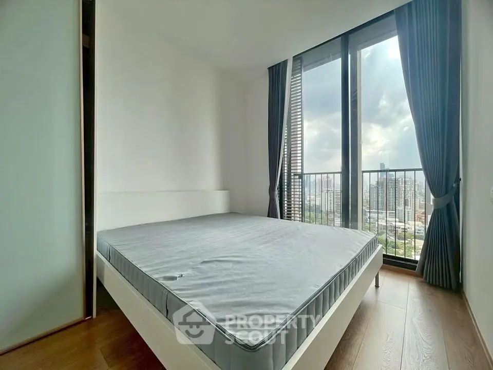 Modern bedroom with large windows offering stunning city views and natural light.