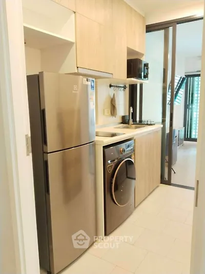 Modern kitchen with sleek appliances and open layout in stylish apartment.