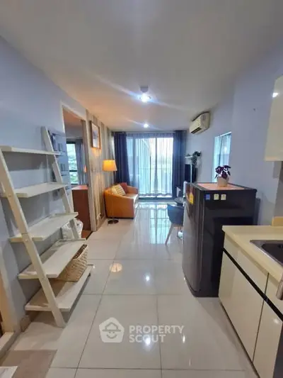 Modern open-plan living room with sleek kitchen and cozy seating area, perfect for urban living.