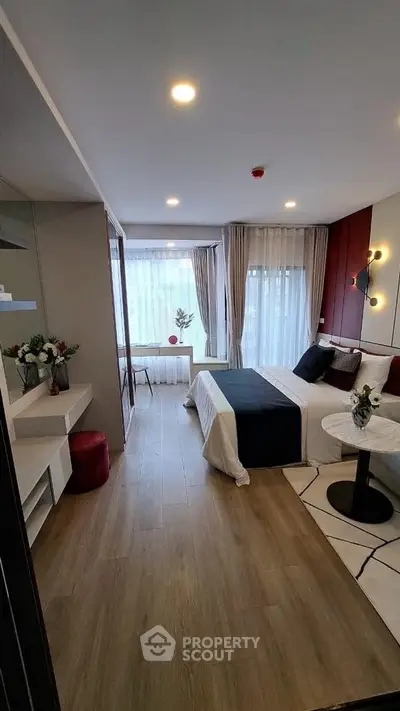 Modern bedroom with elegant decor and large windows offering natural light.