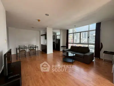 Spacious living room with city view, hardwood floors, and modern furniture in a high-rise apartment.