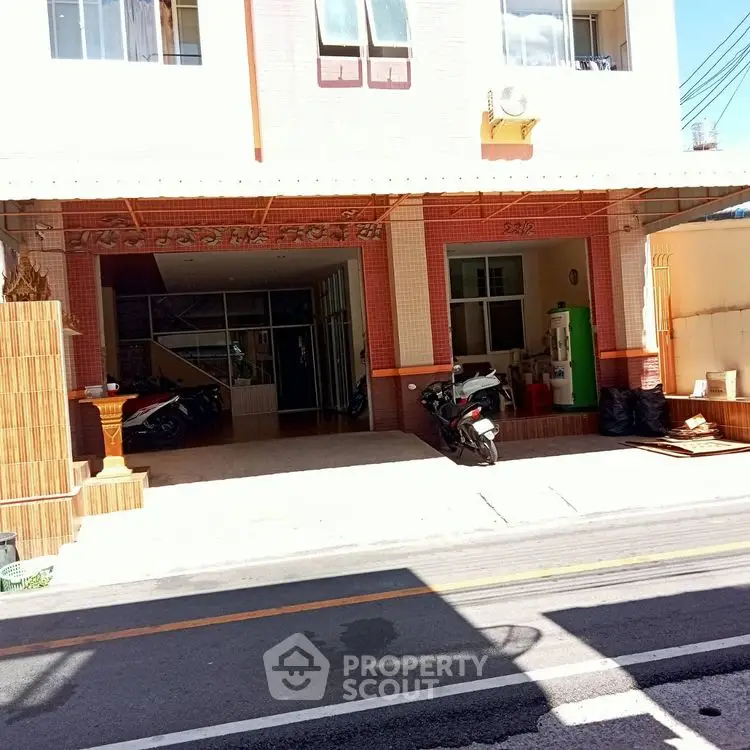 Charming residential building exterior with parking area and motorbikes, perfect for urban living.