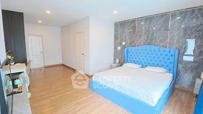 Spacious bedroom with elegant blue bed and modern decor