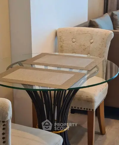 Elegant dining area with glass table and plush chairs in modern apartment