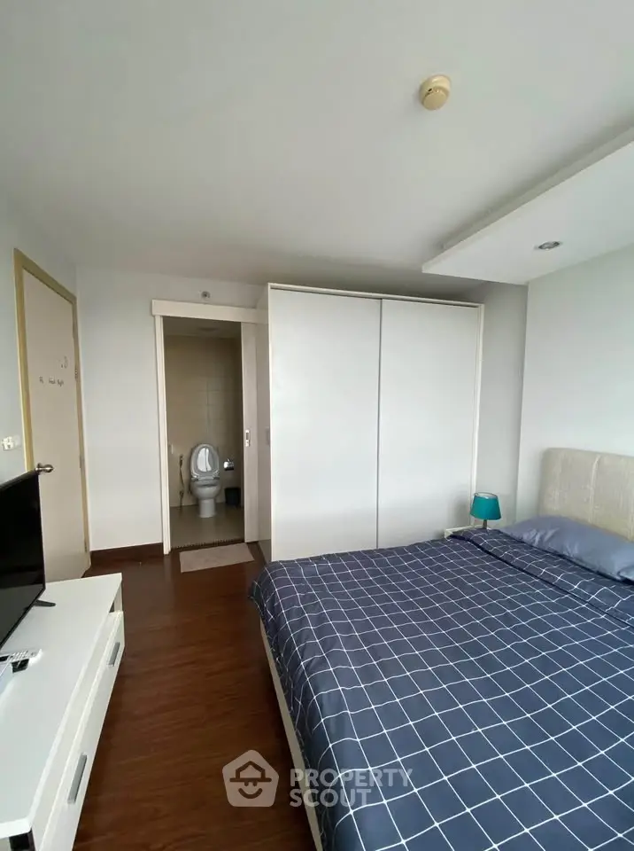 Modern bedroom with ensuite bathroom and stylish decor in a cozy apartment.