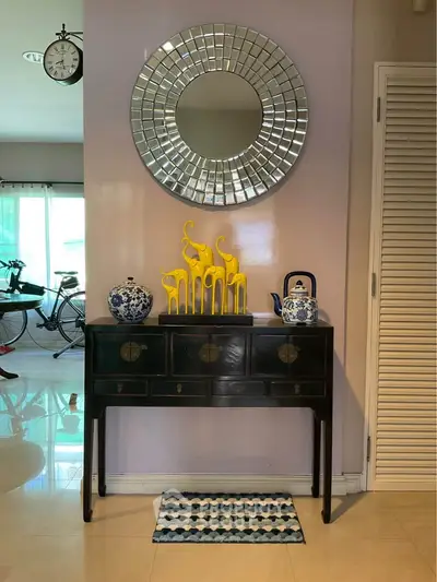 Stylish interior with elegant console table, decorative mirror, and vibrant accents in a modern living space.