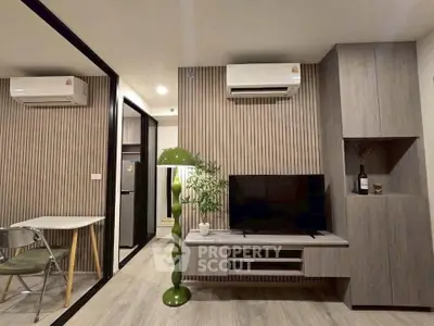 Modern living room with stylish decor, featuring a TV, air conditioning, and a unique green floor lamp.