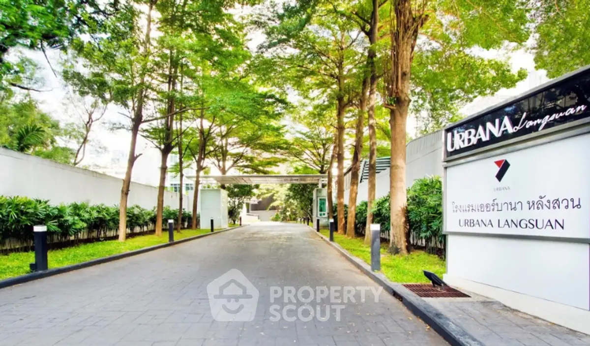 Elegant entrance of Urbana Langsuan with lush greenery and modern signage.