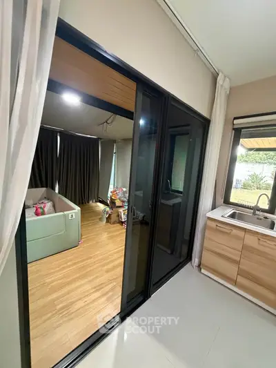Modern interior with sliding glass doors, cozy living area, and sleek kitchen design.