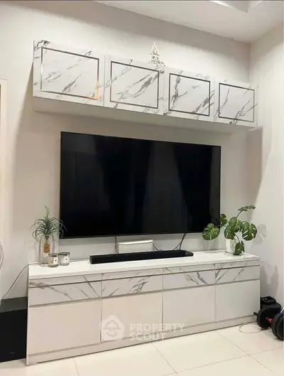 Modern living room with sleek marble cabinetry and large flat-screen TV