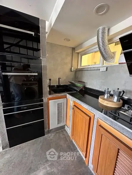 Modern kitchen with sleek black appliances and wooden cabinets