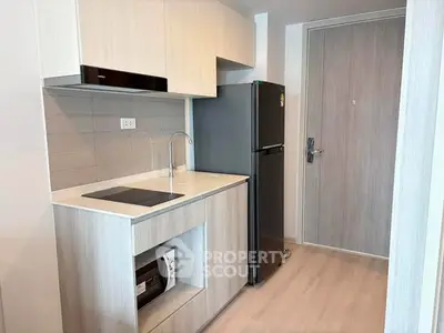 Modern compact kitchen with sleek appliances and minimalist design in a stylish apartment.