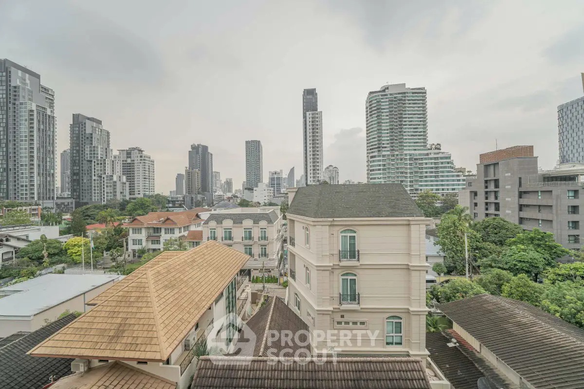 Stunning cityscape view from a high-rise apartment showcasing modern architecture and lush greenery.
