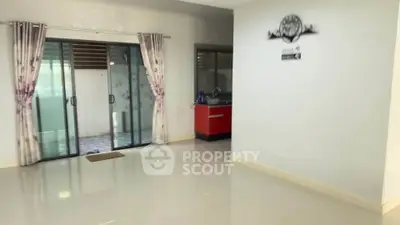 Spacious living area with sliding glass doors and modern kitchen setup
