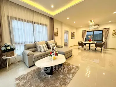 Luxurious open-plan living and dining area with elegant decor and modern lighting.