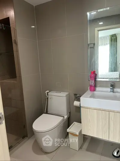 Modern bathroom with sleek fixtures and neutral tones, featuring a glass shower and stylish vanity.