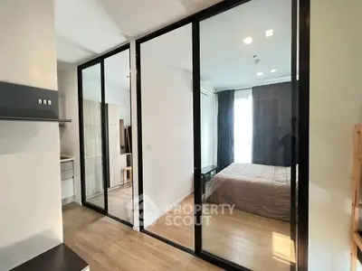 Modern bedroom with glass sliding doors and wooden flooring