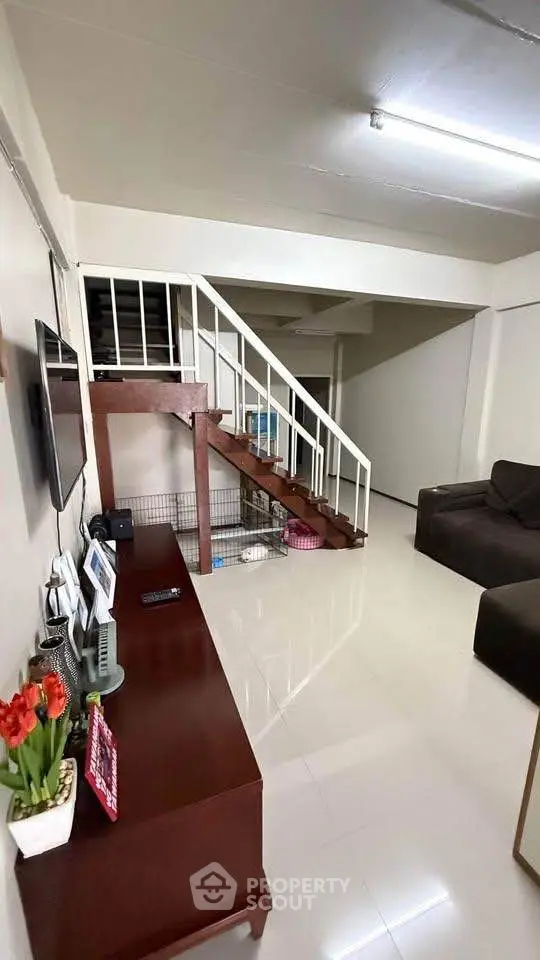 Spacious living room with modern staircase and sleek furniture