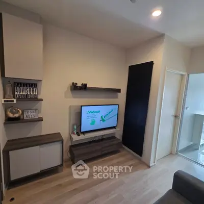 Modern living room with sleek shelving and mounted TV, featuring stylish decor and wood flooring.