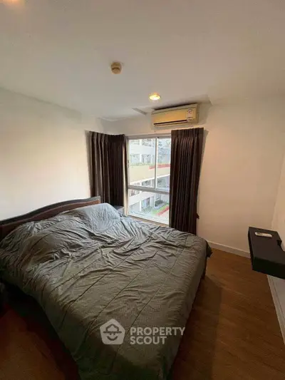 Cozy bedroom with large window and modern air conditioning unit.