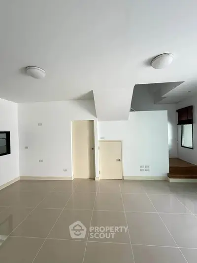 Spacious modern interior with sleek tile flooring and unique architectural design.