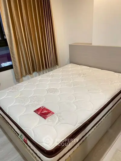 Cozy bedroom with comfortable mattress and elegant curtains, perfect for restful nights.
