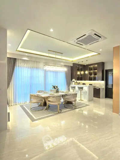 Luxurious open-plan kitchen and dining area with elegant lighting and modern decor.