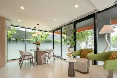 Modern living room with large windows, stylish furniture, and abundant natural light.