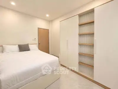 Modern bedroom with sleek white furniture and cozy bedding