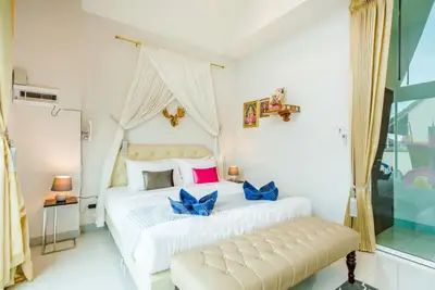Luxurious bedroom with elegant decor and large windows offering natural light.