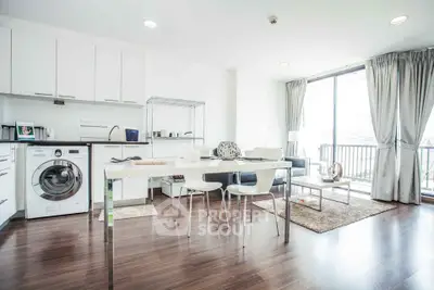 Modern open-plan kitchen and living area with natural light and balcony access.