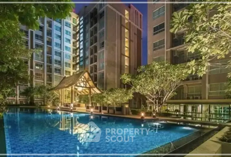 Luxurious condominium with stunning pool and lush greenery at night