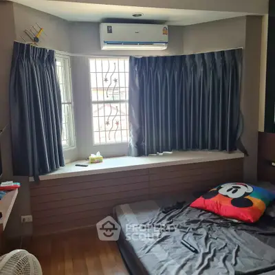 Cozy bedroom with modern air conditioning and stylish curtains, perfect for comfort and relaxation.